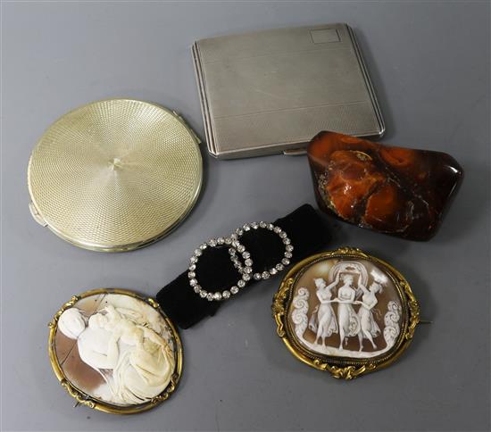 Two silver compacts, an amber pebble, two shell cameos and a pair of paste buckles